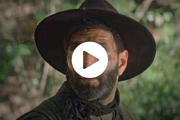 Forbidden Places video screenshot of a man wearing a hat in a wooded forest